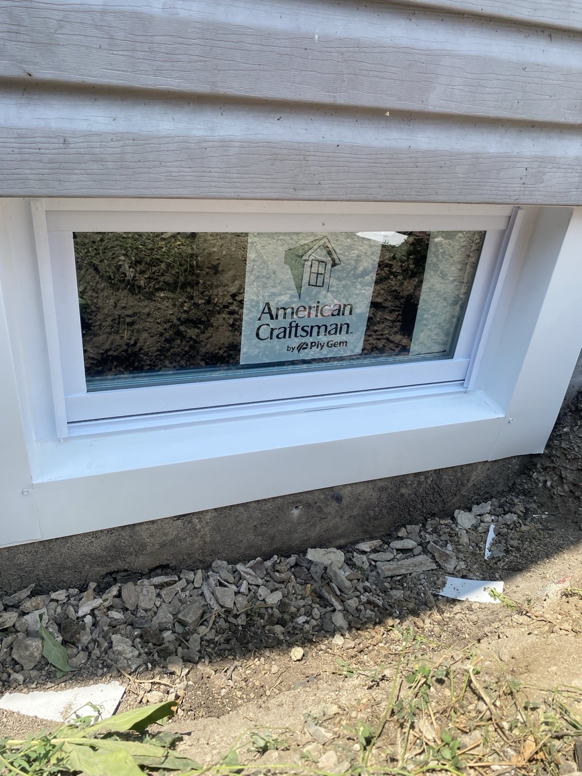Newly installed basement window in exterior siding